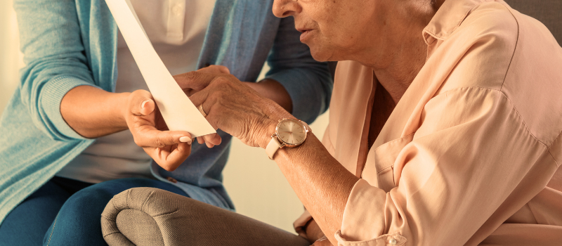 Lady reading a from a page that is held by another women